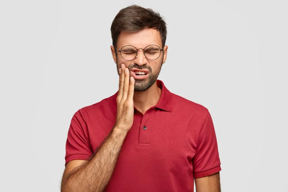a man in red shirt having a toothache