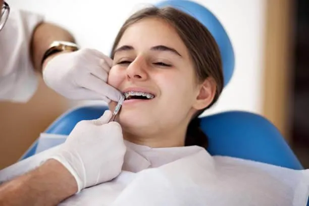 Orthodontist adjusting braces on a child’s teeth during a routine check-up